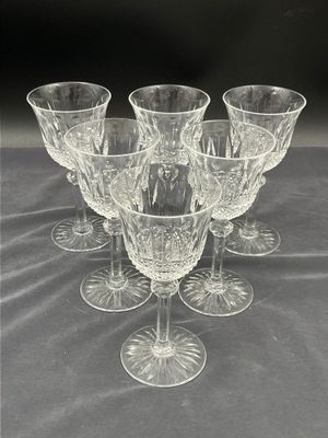 six verres à vin transparents posés les uns à côté des autres sur une table