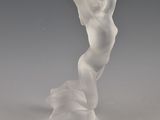 statue d'une femme coiffée d'un chapeau, posée sur un socle blanc