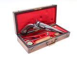 un coffret en bois contenant un pistolet, sur fond blanc