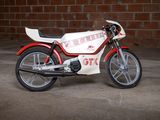 a red and white motorcycle parked in front of a brick wall