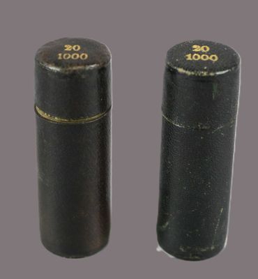 two black cylinders with gold numbers on them sitting next to each other