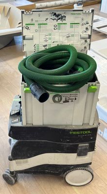 un tuyau vert posé sur un chariot au sol