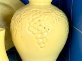 deux vases jaunes posés sur une étagère dans une pièce carrelée de bleu
