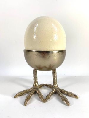 a white egg sitting on top of a metal stand