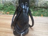a black purse that is sitting on a wooden table