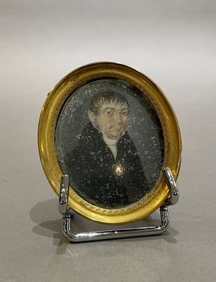 une petite photo représentant un homme en costume, posée sur un socle