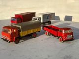 trois camions miniatures posés les uns à côté des autres sur une table