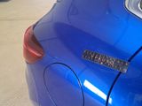 a close up of a blue car with a sticker on it