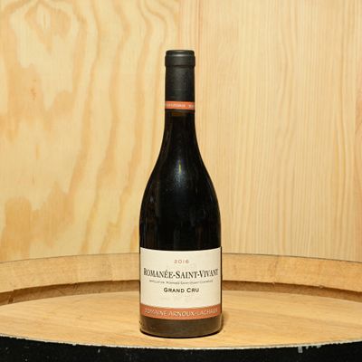 a bottle of wine sitting on top of a barrel