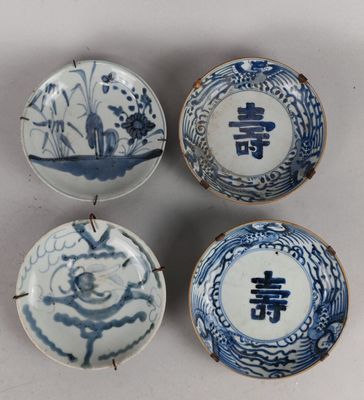 quatre assiettes bleues et blanches ornées de motifs sur fond blanc