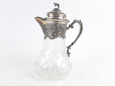 un pichet ancien en verre plaqué argent sur fond blanc