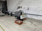 une machine qui se trouve dans un entrepôt, avec un carton posé par terre