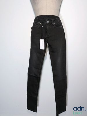 le mannequin tient un jean noir sur un pied de mannequin