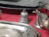 un plateau en argent avec des assiettes et des cuillères en argent, posé sur une nappe rouge