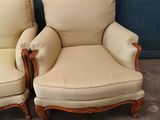 pair of cream upholstered chairs in a room with a blue door