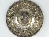 a silver plate with a picture of a woman on it