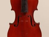 an old violin sitting on top of a white surface