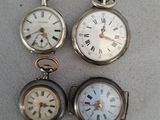 trois montres de poche différentes posées sur une table