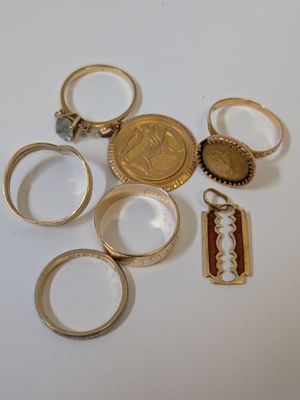 beaucoup de bagues en or et une pièce de monnaie sur la table