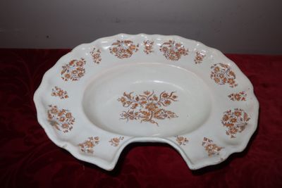 une assiette blanche ornée de fleurs marron, posée sur une table rouge