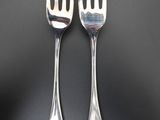 pair of silverware fork and spoons on a black surface
