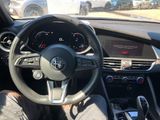 the steering wheel and dashboard of a car with a person sitting in the drivers seat