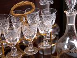 many glasses and a decanter sitting on a table