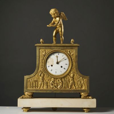 an image of a gold clock sitting on top of a white table