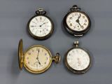 Quatre types différents de montres de poche sont exposés sur une table