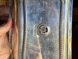 a person holding a silver tray with a handle