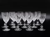 six verres à vin sont alignés sur une surface noire