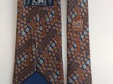 two ties with blue and brown designs on them hanging on a wall