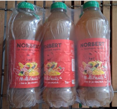 trois bouteilles de jus d'orange posées sur une étagère