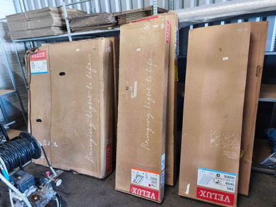 Plusieurs cartons contenant des articles divers sont empilés les uns sur les autres dans un entrepôt.