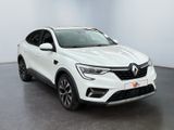 a white car parked in a white room with a black floor