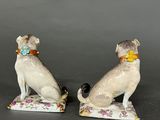 pair of porcelain figurines of two dogs sitting on top of each other
