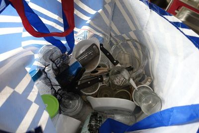un sac bleu et blanc rempli d'argent et d'objets en argent