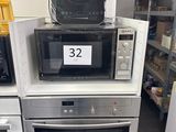 trois micro-ondes empilés les uns sur les autres dans un magasin