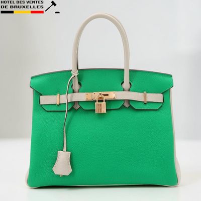 un sac Hermès vert avec un fermoir doré sur la poignée