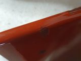 a close up of a red cell phone on a white surface