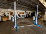 a picture of a garage with two lifts in the middle of it