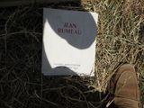 un livre posé par terre à côté des chaussures d'une personne