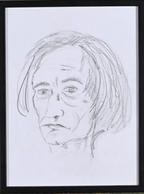 drawing of a woman ' s face in a black frame on a table