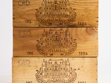 three wooden boxes with different types of wine are stacked on top of each other