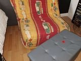 un fauteuil-futon et un repose-pieds dans un coin de la chambre