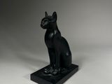 une image représentant une statue de chat assis sur un socle