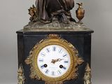 une statue de femme assise au sommet d'une horloge