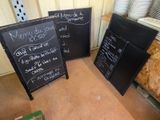 trois tableaux noirs posés par terre les uns à côté des autres