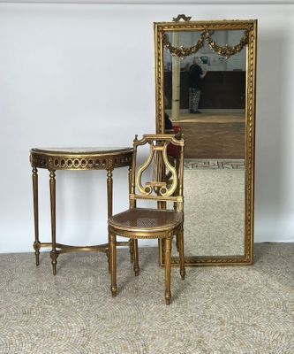 une petite table avec un miroir et une chaise placée devant