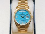 an image of a gold watch with a blue dial and roman numerals